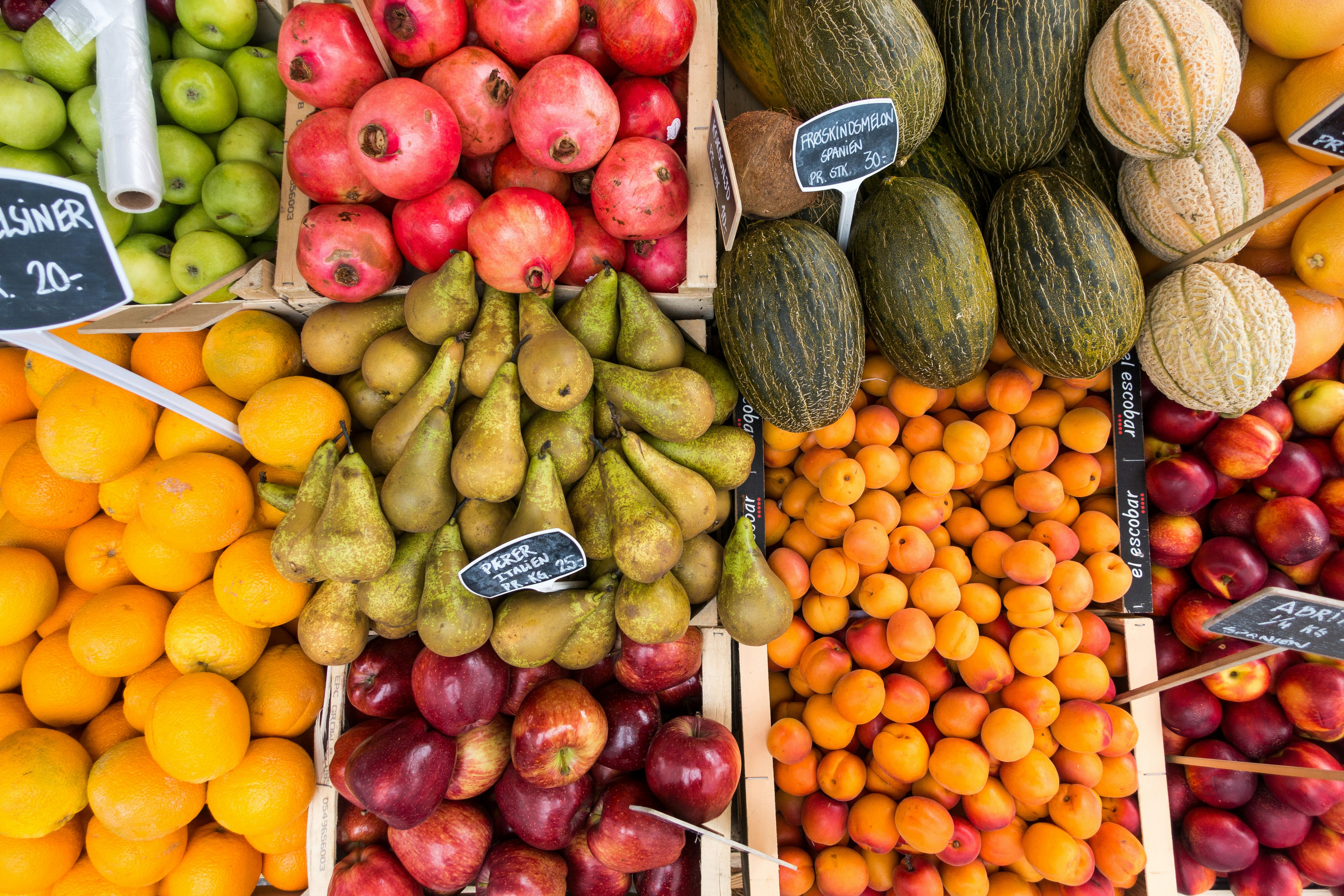 A table with several boxes filled with different kinds of fruits.